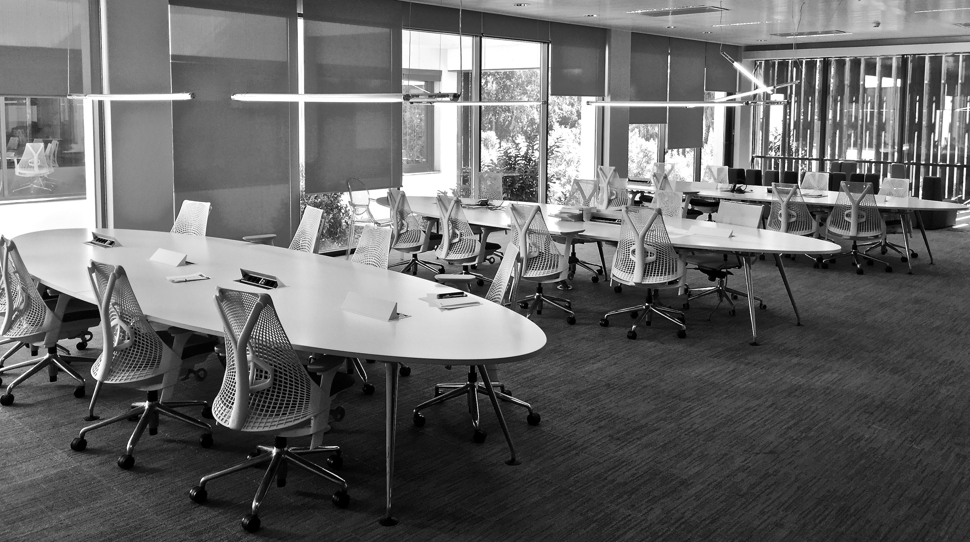 an empty open-space office. Large oval  tables surrounded by chairs
