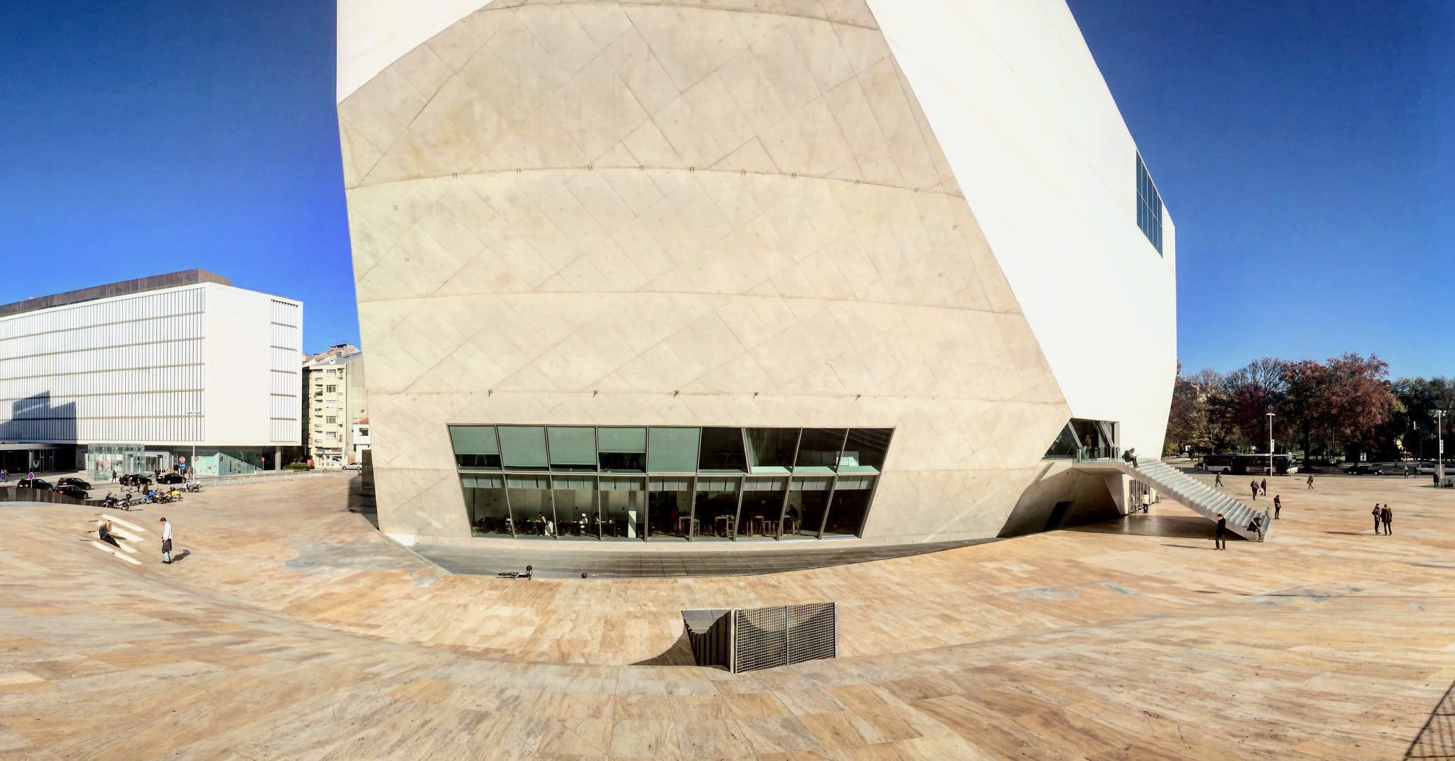 a large geometrical building sits at the center of a bowl-shaped plaza