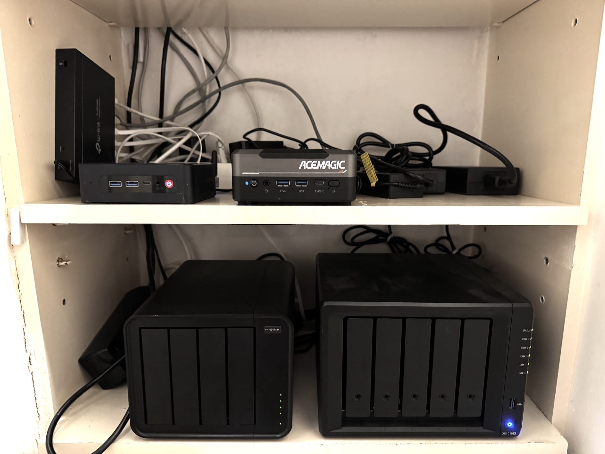 Homelab setup showing servers and networking equipment in a closet with the UPS underneath on the floor