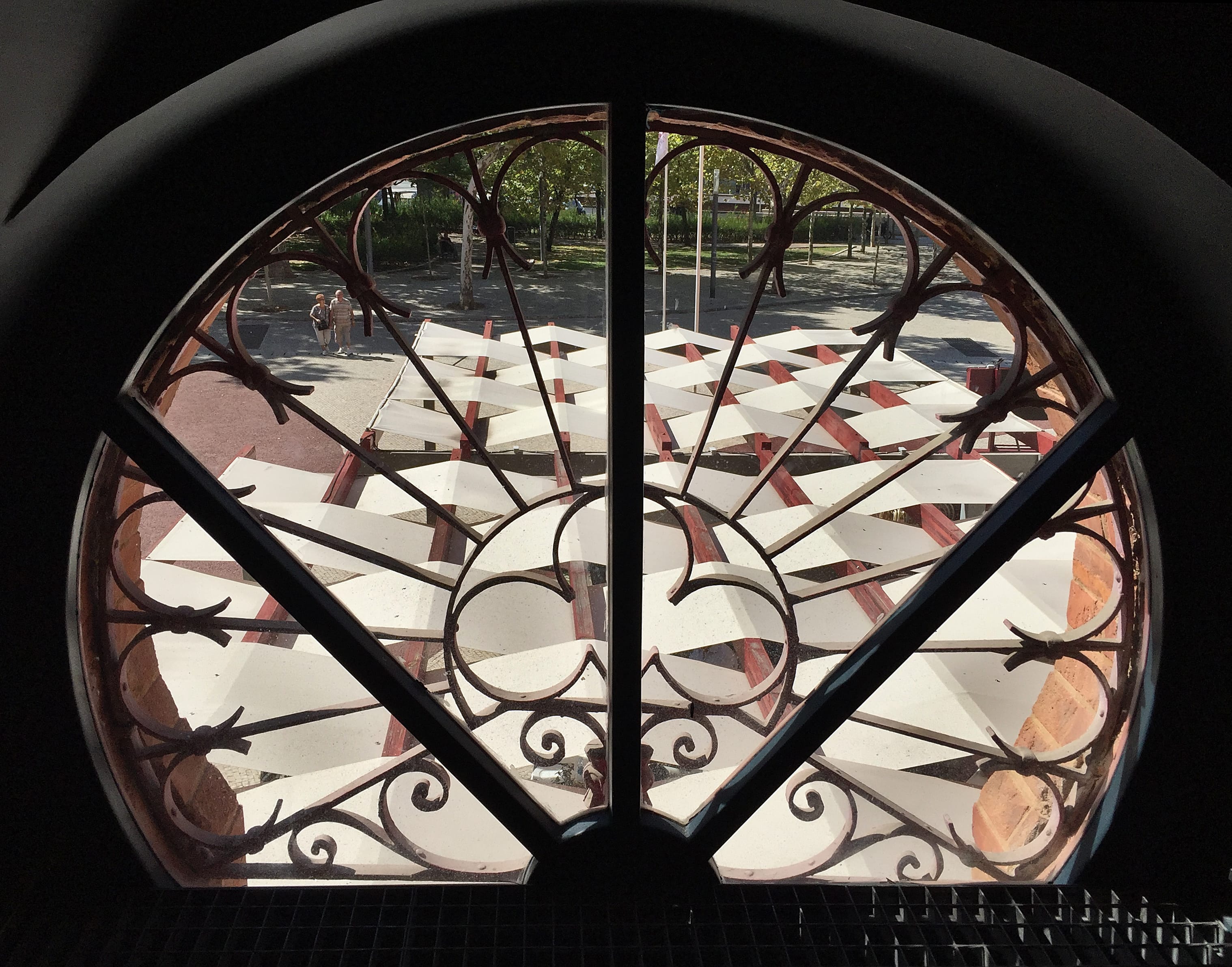 an awning seen from a round window with iron works