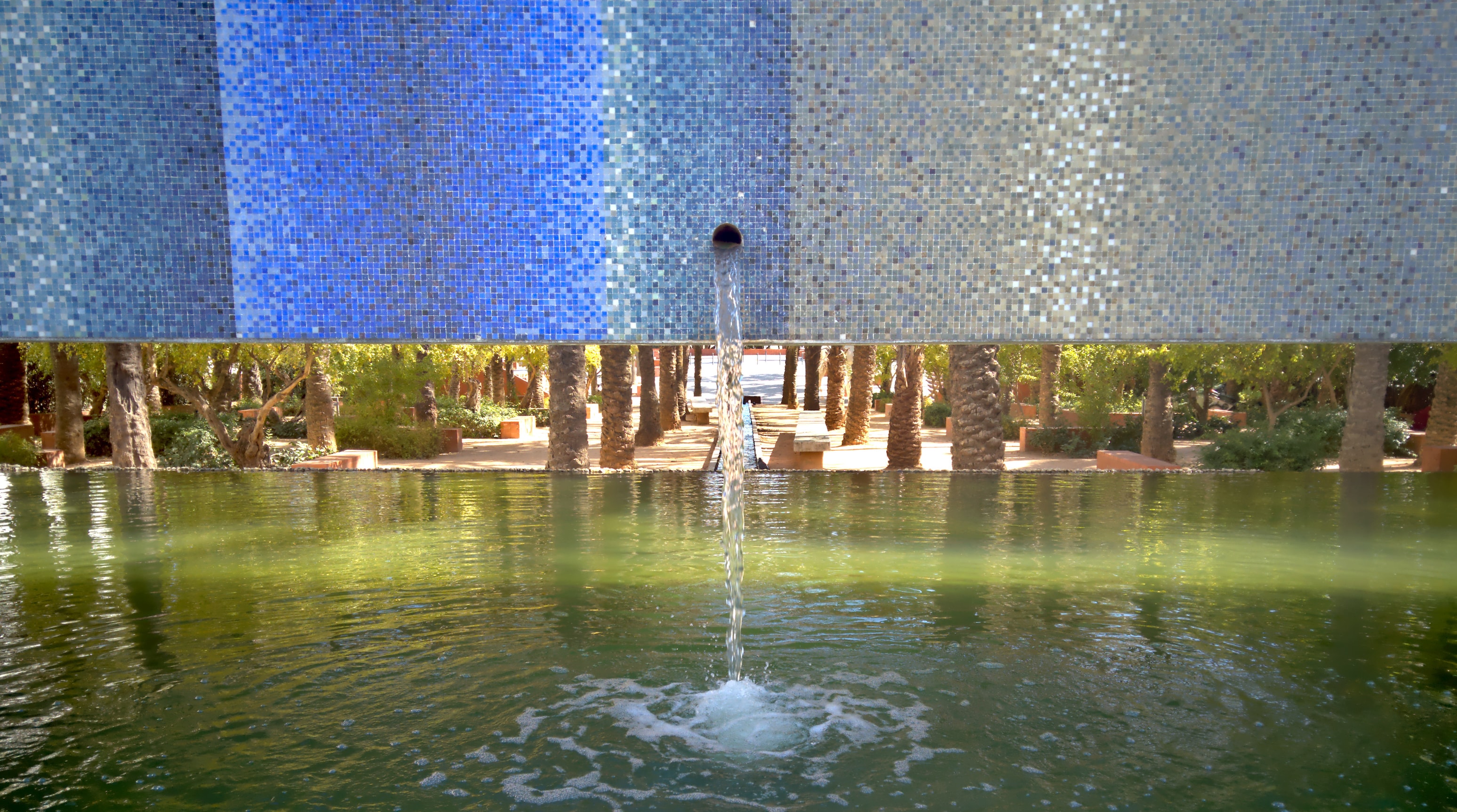 a tile-fronted fountain flows into a pond