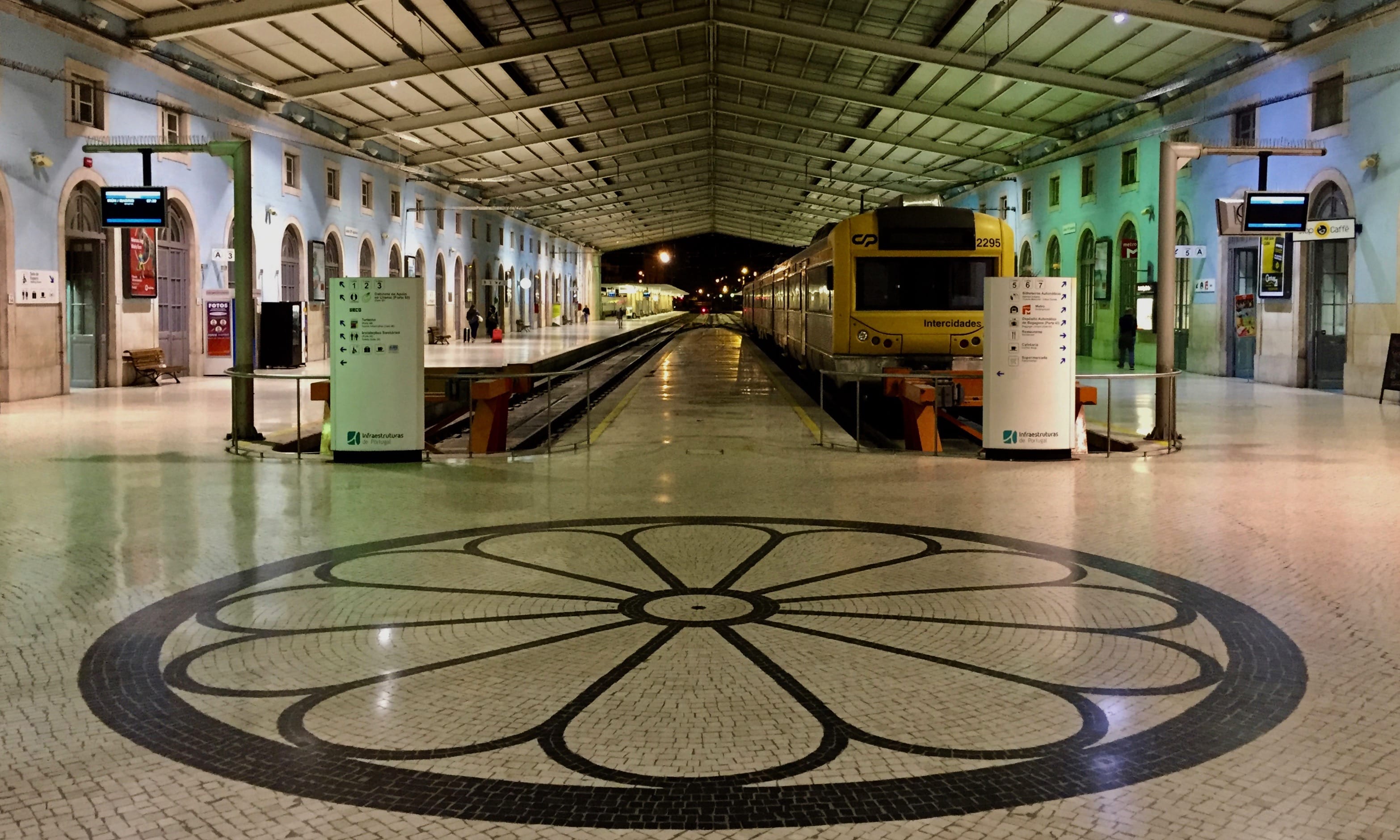 a train station. A train sits to the right of another empty track