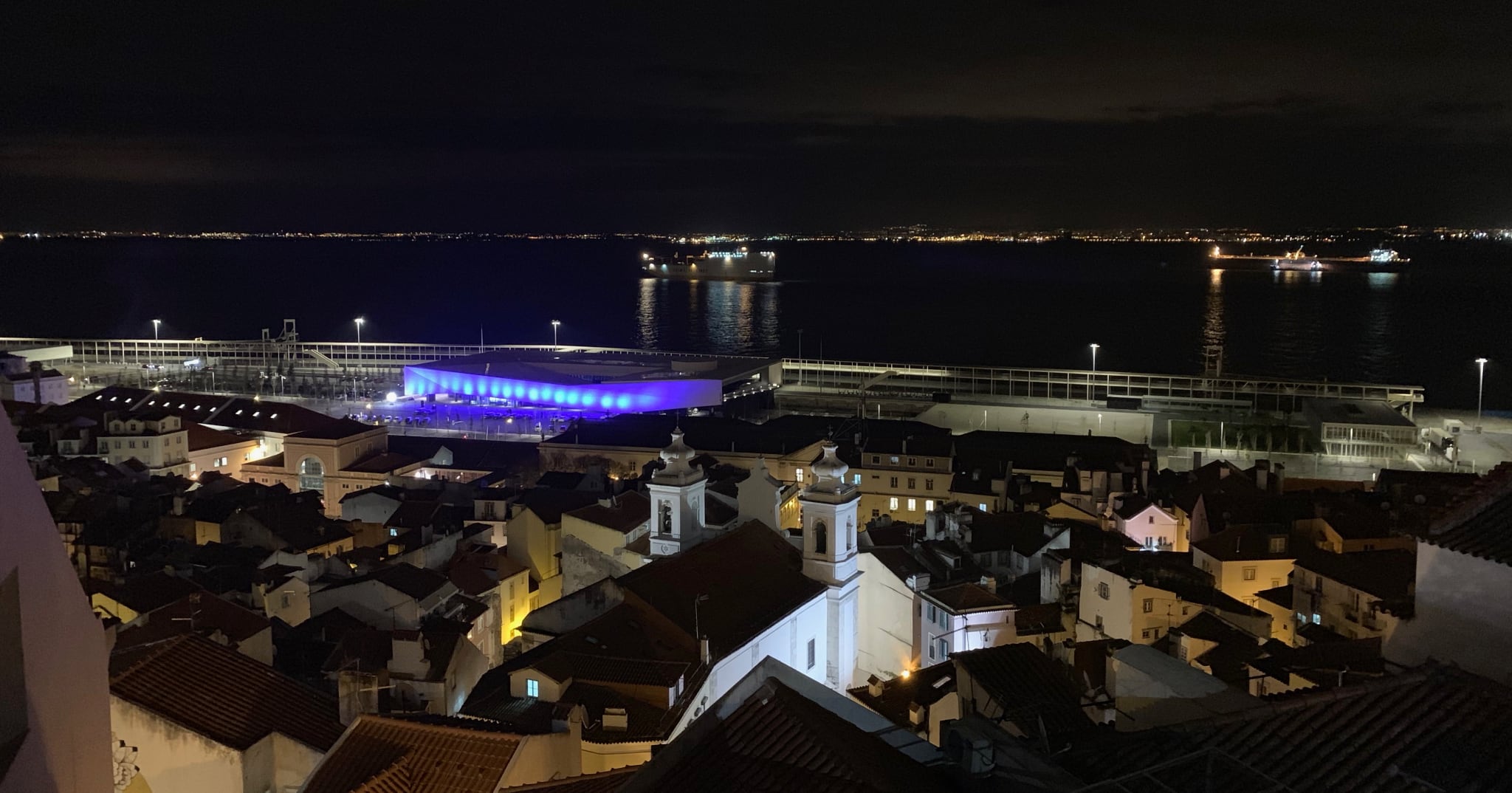 tiled roofs sloping down to the river at night time